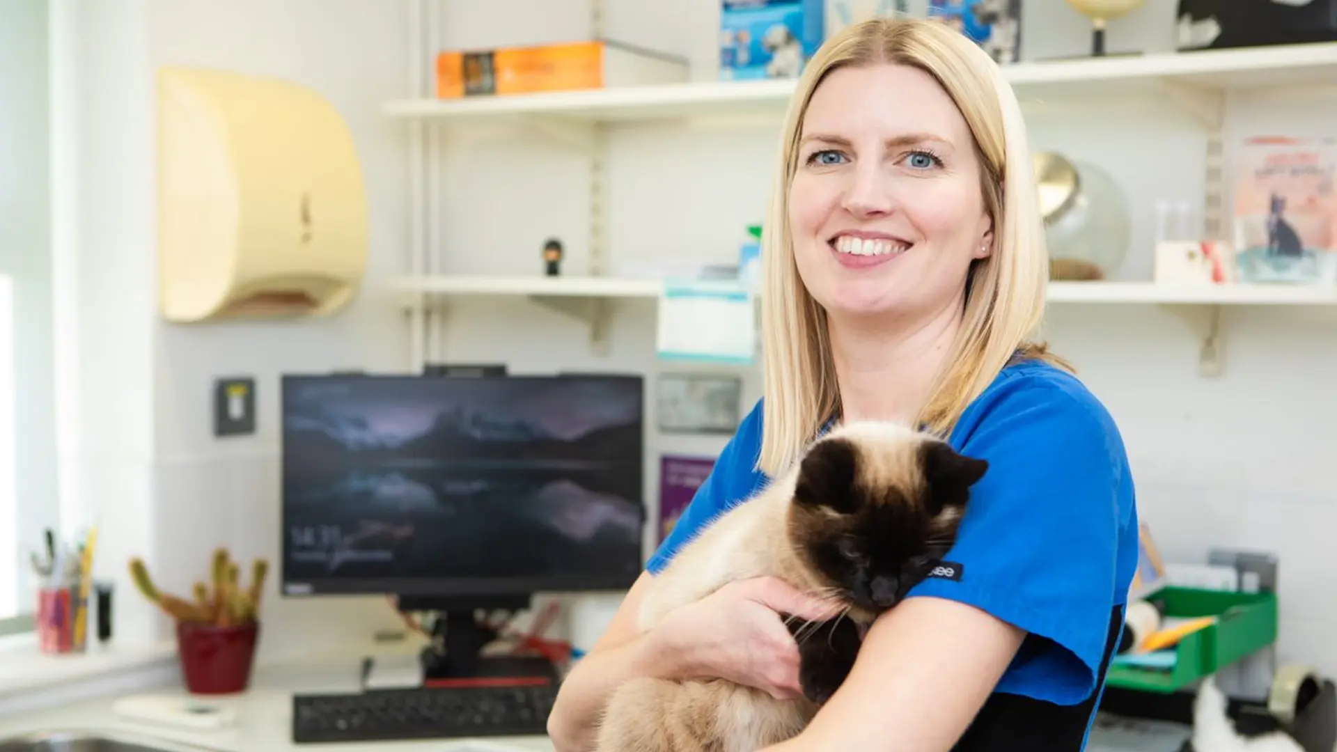 smiling vet holding a cat