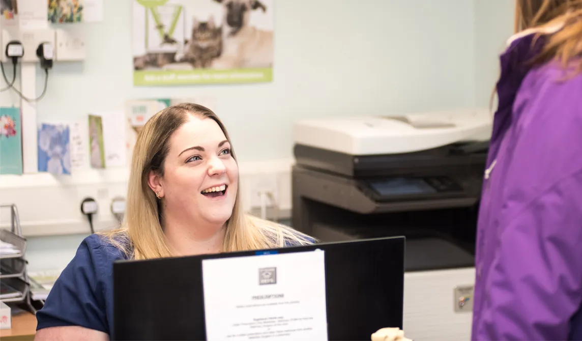 veterinary receptionist laughing with customer