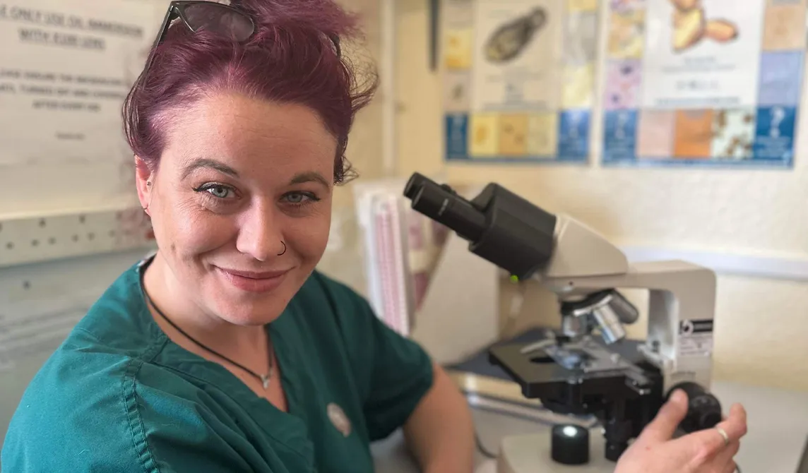 veterinary nurse sitting in front of microscope